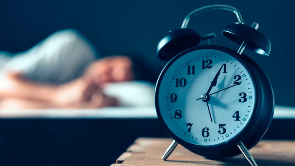 Alarm clock beside someone's bed